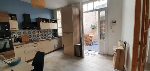 uma cozinha com uma porta aberta para uma sala de jantar em Maison de ville, Bergerac historique tout à pied em Bergerac