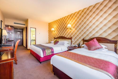 a hotel room with two beds and a desk at Beijing Commercial Business Hotel in Beijing