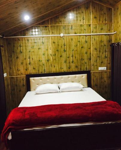 a bedroom with a large bed with wooden walls at Golden valley cottages, Chail in Chail