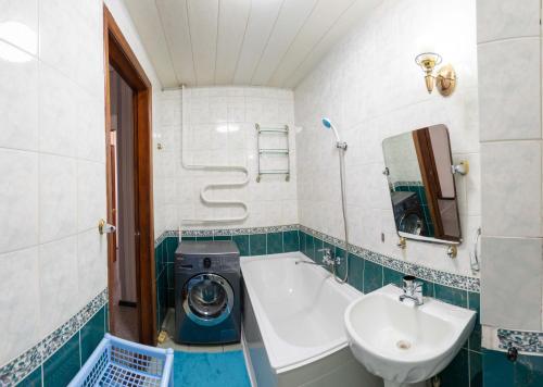 a bathroom with a washing machine and a sink at Дом с прекрасным видом г Павлодар in Pavlodar