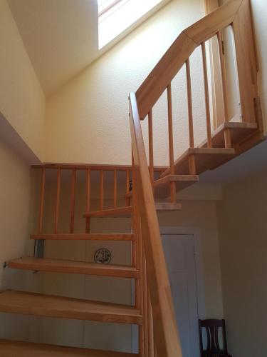 a wooden staircase in a room with a skylight at Über den Dächern von Ahlbeck in Ahlbeck