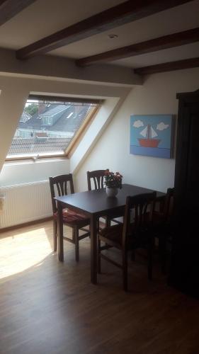 a dining room with a table and chairs and a window at Über den Dächern von Ahlbeck in Ahlbeck