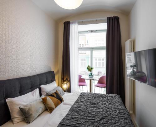 a bedroom with a bed and a window and a table at MN6 Luxury Suites by Adrez in Prague