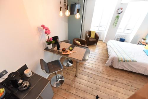 a living room with a bed and a table and a bed at Studio 86 - Climatisation & proche centre-ville- 2 personnes - BnB Epernay in Épernay