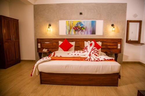 a bedroom with a large bed with red pillows at Seasons Villa - Nuwara Eliya in Nuwara Eliya