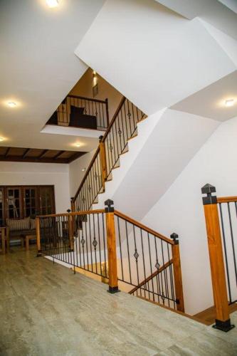 a staircase in a house with wooden railings at Seasons Villa - Nuwara Eliya in Nuwara Eliya