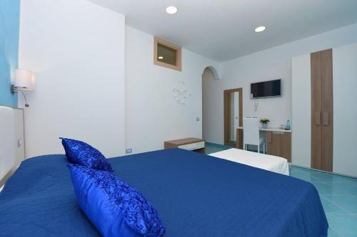 a blue bed with a blue pillow in a bedroom at Le Perle d'Italia in Ravello