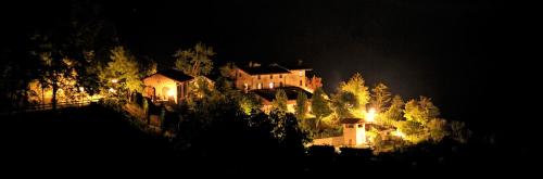 a house on top of a hill at night at Agriturismo Sondrea in Sinio