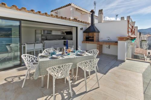 patio con mesa y sillas en el balcón en Playa Vista Mar Duplex, en Port de la Selva