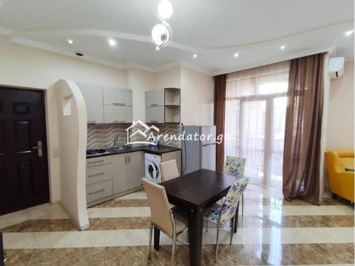 a kitchen and dining room with a table and chairs at Apartment Face in Batumi