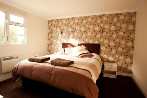 ニューキーにあるLavender lodgeの花柄の壁紙を用いたベッドルーム1室(大型ベッド1台付)