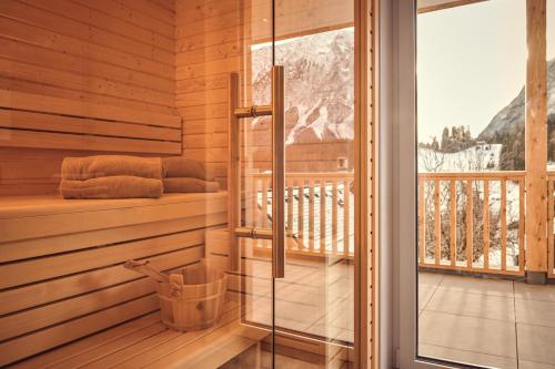 a sauna with a bench and a balcony with a window at die Tauplitz Lodges - Alm Lodge A6 by AA Holiday Homes in Tauplitz