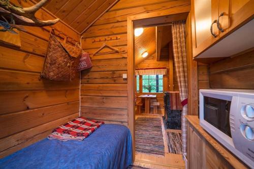 a bedroom in a log cabin with a bed and a tv at Vuorijärvi cottage in Enonkoski