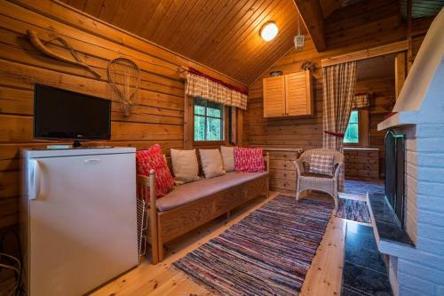 a living room with a couch and a tv in a cabin at Vuorijärvi cottage in Enonkoski