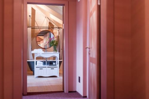 a hallway with a bathroom with a sink and a mirror at Hotel De Londres in Brig