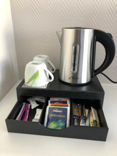 a black shelf with a coffee pot and a cup at Haus Marquet in Saint-Vith