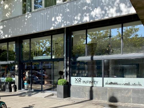 ein Glasgebäude mit einem Vos-Infinity-Schild darauf in der Unterkunft XO Hotels Infinity in Amsterdam