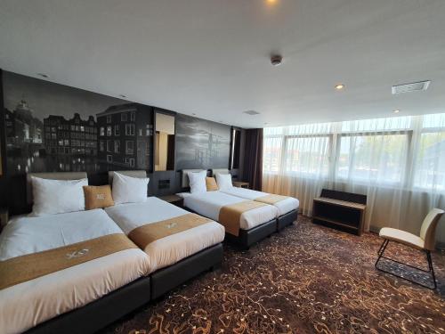 a hotel room with two beds and a large window at XO Hotels Infinity in Amsterdam