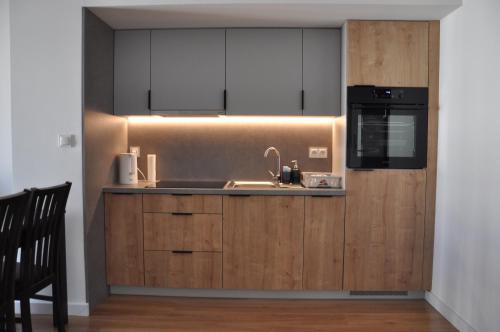 a kitchen with a sink and a microwave at WROCLOVE_NET APARTMENTS in Wrocław