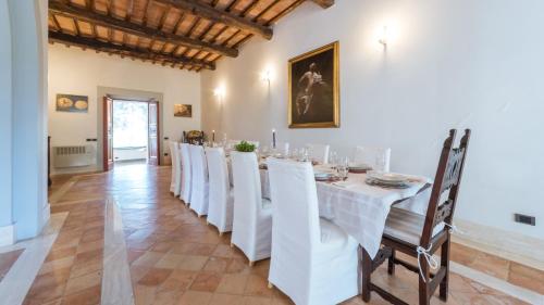 a dining room with a white table and chairs at BORGO COLLE RIDENTE 13, Emma Villas in Camerino