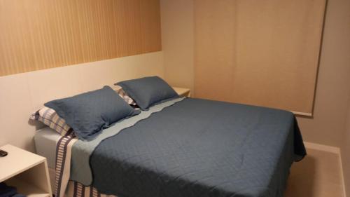 a bedroom with a bed with blue sheets and pillows at GUARAJUBA - Apartamento MÁXIMO 4 PESSOAS -2 quartos - 170 m da praia in Guarajuba