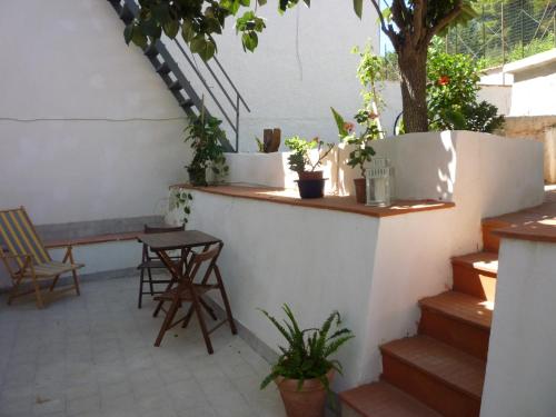 a patio with a table and chairs and potted plants at Casa Betta e Elisa in Valderice