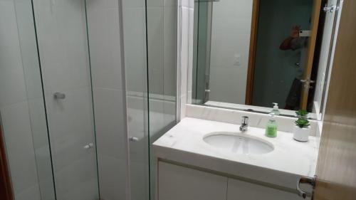 a bathroom with a sink and a shower with a mirror at GUARAJUBA - Apartamento MÁXIMO 4 PESSOAS -2 quartos - 170 m da praia in Guarajuba