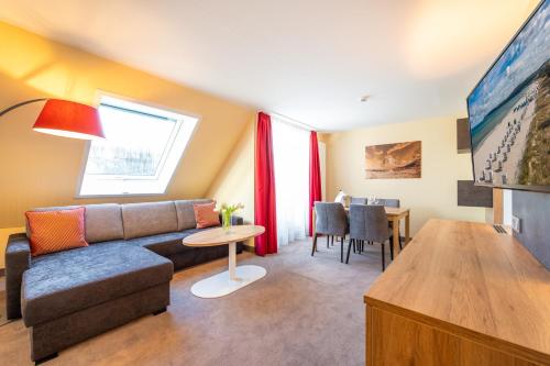 a living room with a couch and a table at Centralhotel Binz in Binz