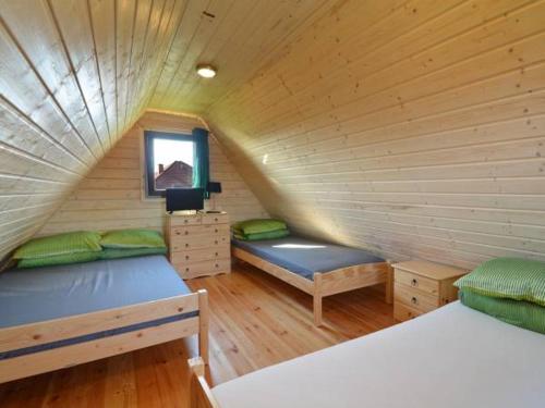 a attic room with two beds and a window at Domki Kaja in Rewal