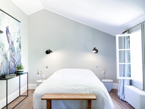 a white bedroom with a bed and a table at Le Vivier in Trigny