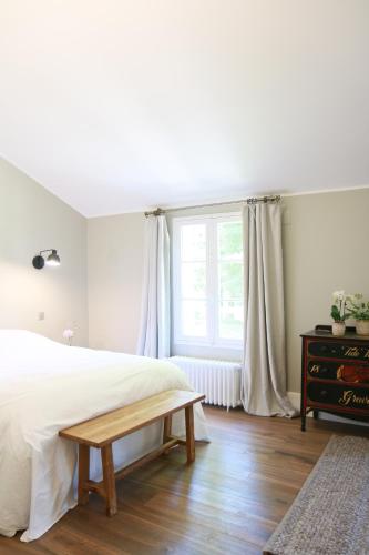 a bedroom with a white bed and a window at Le Vivier in Trigny