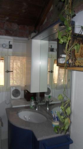 une salle de bain avec un lavabo et un miroir dans l'établissement La vieille maison Biselli, à Tende