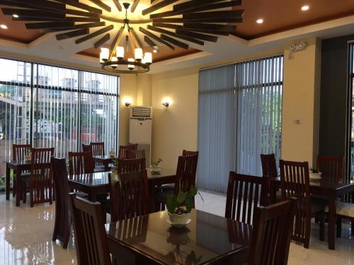 uma sala de jantar com mesas e cadeiras e um lustre em Bohol Ecotel em Tagbilaran