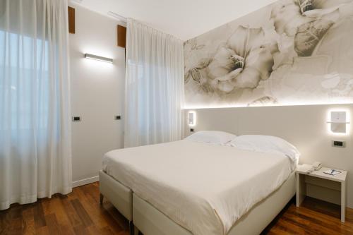 a bedroom with a bed with a painting on the wall at Hotel Giulietta e Romeo ***S in Verona