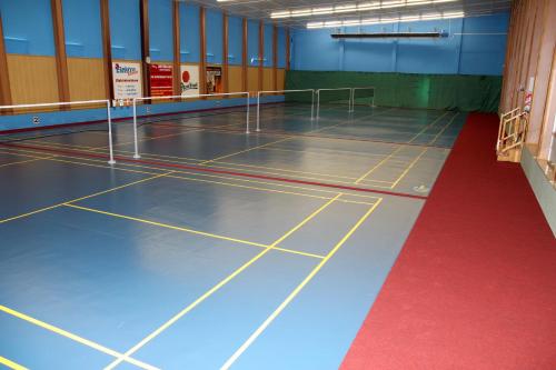 a volleyball court in a gym with a red floor at Penzion U Splavu in Břeclav