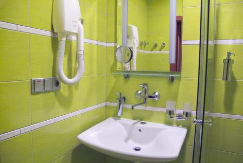 ein Bad mit einem Waschbecken und einem Spiegel in der Unterkunft Penzion U Splavu in Břeclav