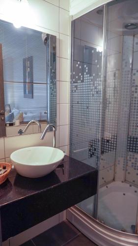a bathroom with a sink and a shower and a tub at Koza Suite Hotel in Ankara