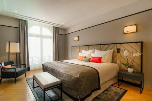 
a hotel room with a large bed and a large window at Fraser Suites Le Claridge Champs-Elysées in Paris
