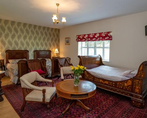 a living room with a bunch of beds and a table at The Dales in Gorey