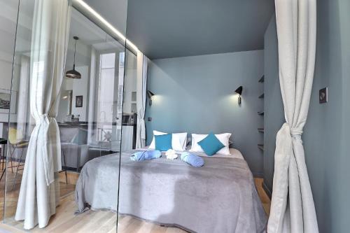 Appartement entier - refait à neuf - Loft - City Center في ليون: غرفة نوم زرقاء مع سرير ووسائد زرقاء