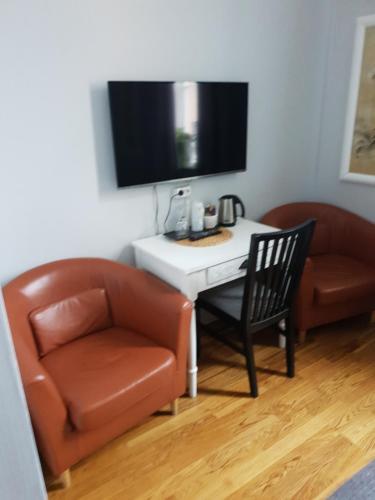 a living room with a table and a chair and a tv at Nora Stadshotell, Sure Hotel Collection by Best Western in Nora