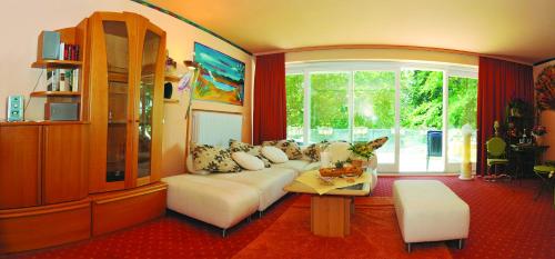 a living room with a white couch and a table at Eden Hotel in Bad Krozingen