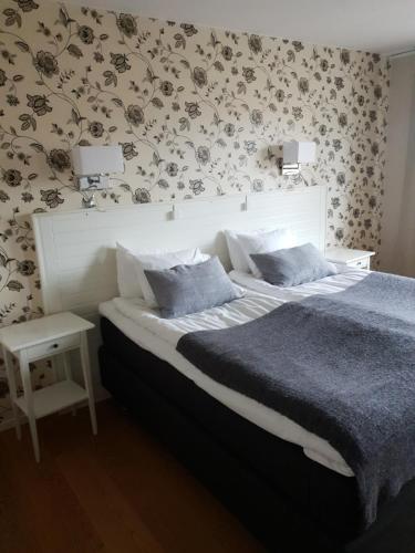 a bedroom with a large bed with a floral wallpaper at Nora Stadshotell, Sure Hotel Collection by Best Western in Nora