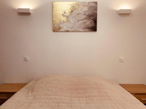 une chambre avec un lit et un tableau au mur dans l'établissement L'Appart'à-G, à Gérardmer