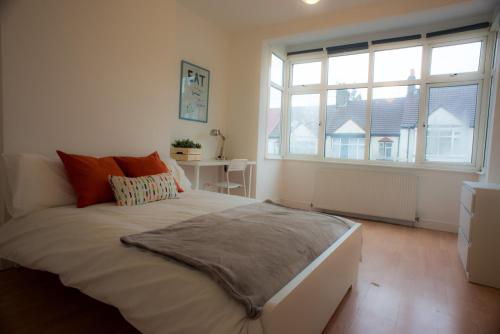 ein Schlafzimmer mit einem großen Bett und einem großen Fenster in der Unterkunft Tooting Bec Rooms by DC London Rooms in London