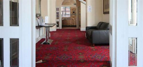 a living room with a couch and a red carpet at The Knighton Hotel in Knighton