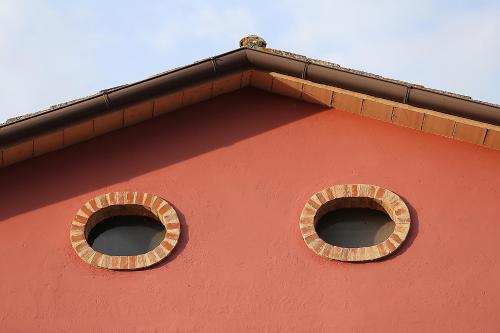 two windows on the side of a red building at Agriturismo Il Sarale - Umbria in Città di Castello