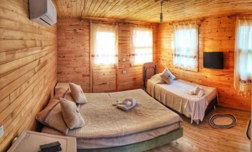 1 dormitorio con 2 camas en una cabaña de madera en KARABİBİK BUNGALOW en Demre