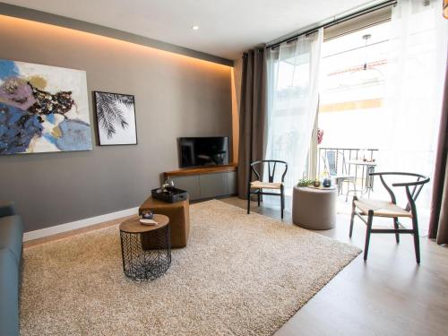 a living room with chairs and a large window at Sitges Spaces Seaside Beach Flat with Terrace in Sitges
