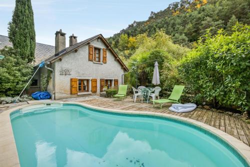 une maison avec une piscine devant une maison dans l'établissement Villa spacieuse à Saint-Pierre-des-Tripiers avec piscine privée, à Saint-Pierre-des-Tripiers